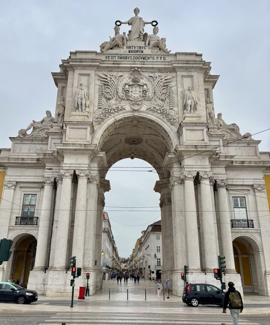 Ornate stone triumphal arch rising over a city street
