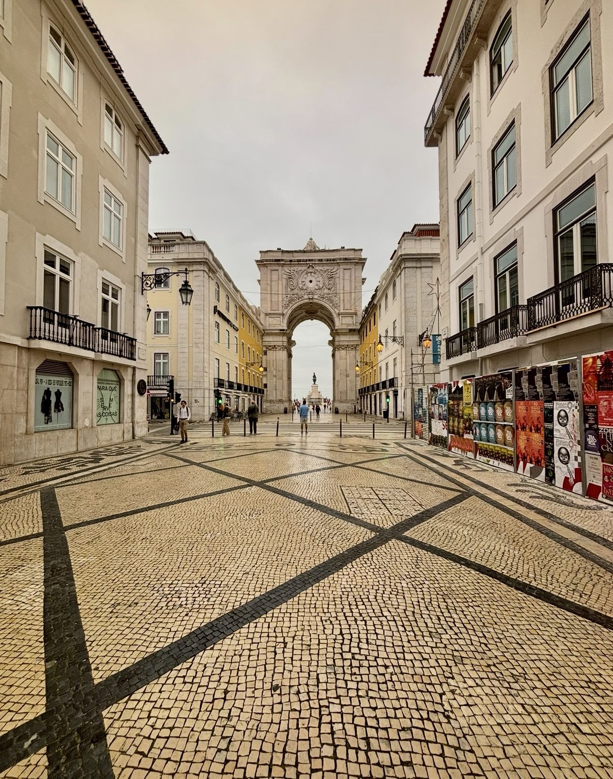 Patterned cobblestone plaza leading toward a grand archway