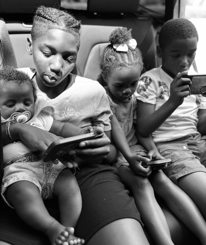 Four siblings together in black and white, a quiet candid moment